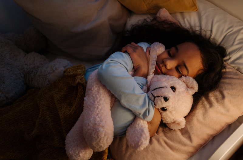 kind schläft mit teddybär